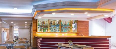 Un restaurant doté d’un bar, de tables et de chaises.