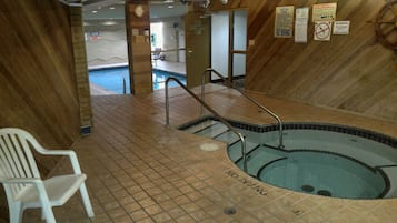 Zona de piscina con suelo de baldosas, una silla blanca y varias señales, incluyendo 'NO DIVING'.
