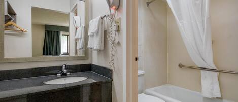 A bathroom with a sink, mirror, towel rack, and a shower curtain.