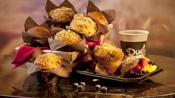 Un plateau avec des muffins et une tasse de café, sur un fond flou.