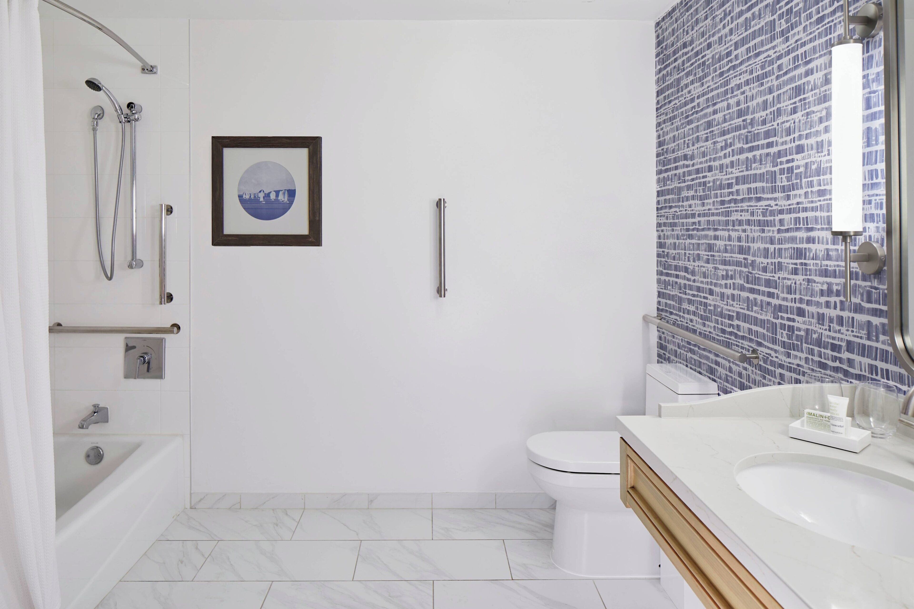 A modern bathroom with a bathtub, toilet, and sink.