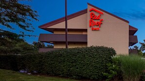 A Red Roof Inn with a modern design, featuring a flat roof and a prominent red sign. - Red Roof Inn Lexington South (Lexington)