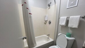 A bathroom with a bathtub, toilet, and shower curtain. - Red Roof Inn Lexington South (Lexington)
