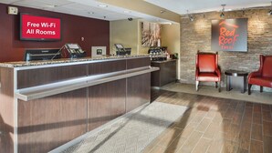Un espace d’accueil comprenant un comptoir, une machine à café et un panneau indiquant que le Wi-Fi est disponible gratuitement.
