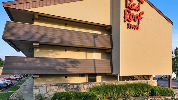Un hôtel Red Roof Inn, avec une structure à deux étages, un toit plat et des fondations en pierre.