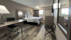 Une chambre d’hôtel équipée d’un lit, d’un bureau, d’une chaise et d’un téléviseur.