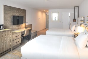 A hotel room with a wooden desk, a flat-screen TV, two beds, a chair, and a mirror. - Doubletree by Hilton Campbell - Pruneyard Plaza (Campbell)