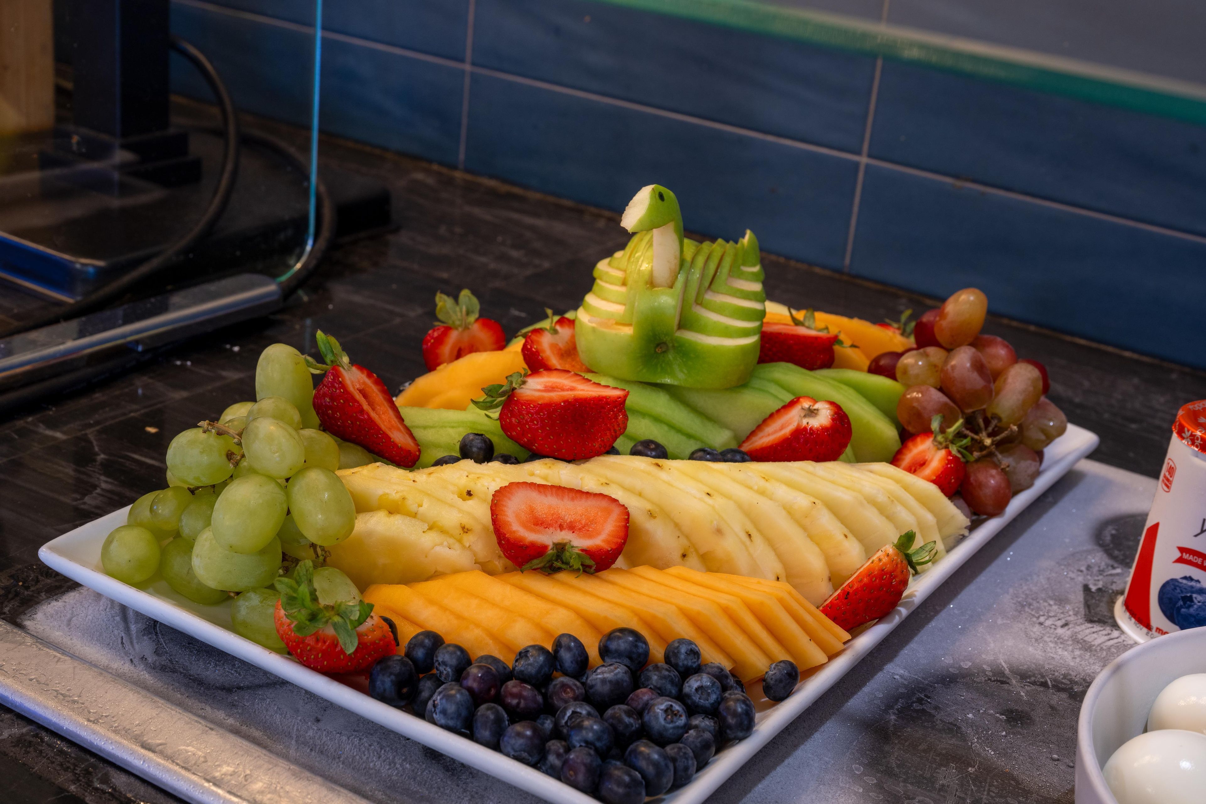 A fruit platter with various fruits including grapes, strawberries, and bananas.