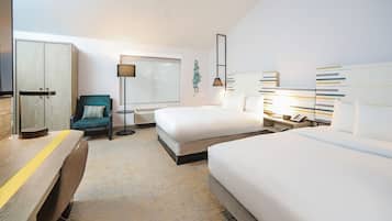 A modern hotel room with a desk, two beds, a chair, a lamp, and a window.