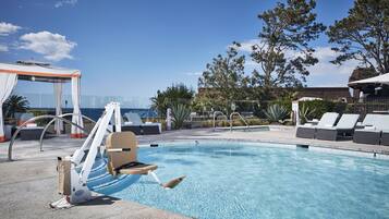 A swimming pool with lounge chairs and a canopy.