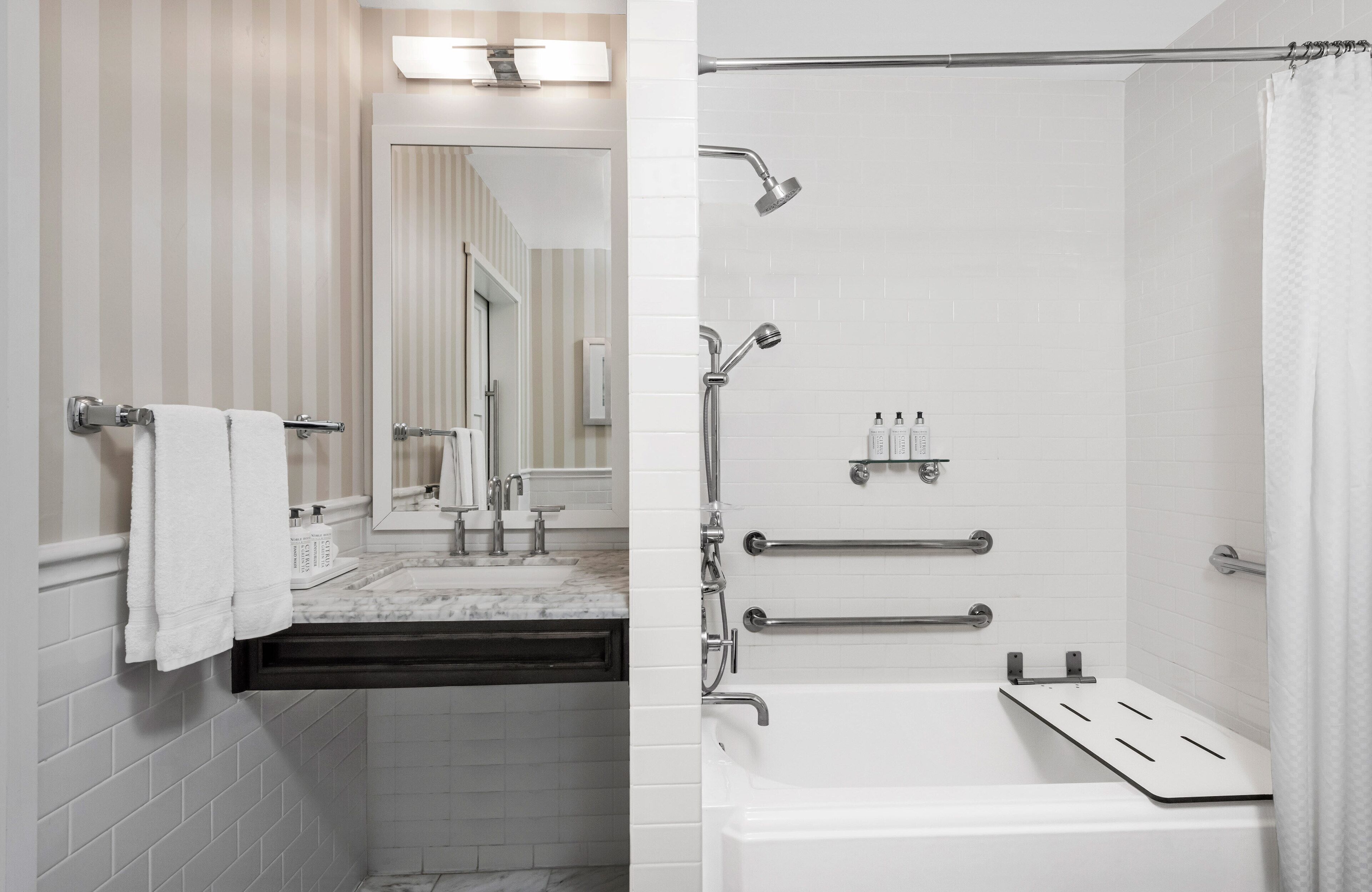 Un baño moderno con ducha, lavamanos y espejo.