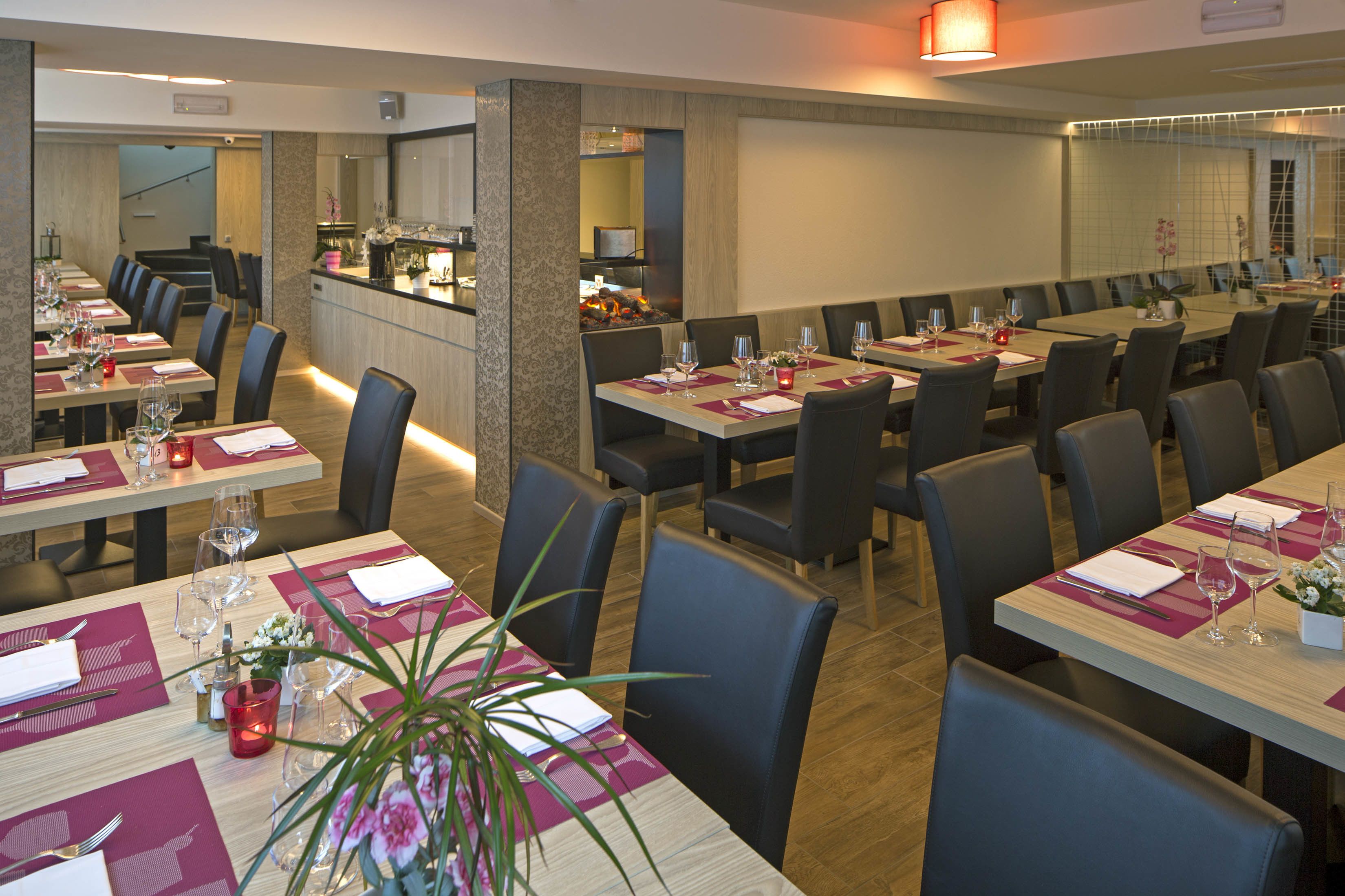A restaurant with multiple dining tables, chairs, and a bar area.