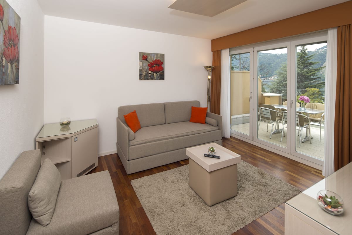 overview suite, balcony, lake view | living room | tv, ipod dock