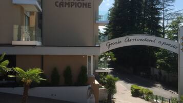 A hotel entrance with a sign reading "HOTEL CAMPIONE" and a welcoming message in Italian.
