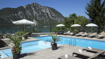 Una piscina al aire libre de temporada, sombrillas