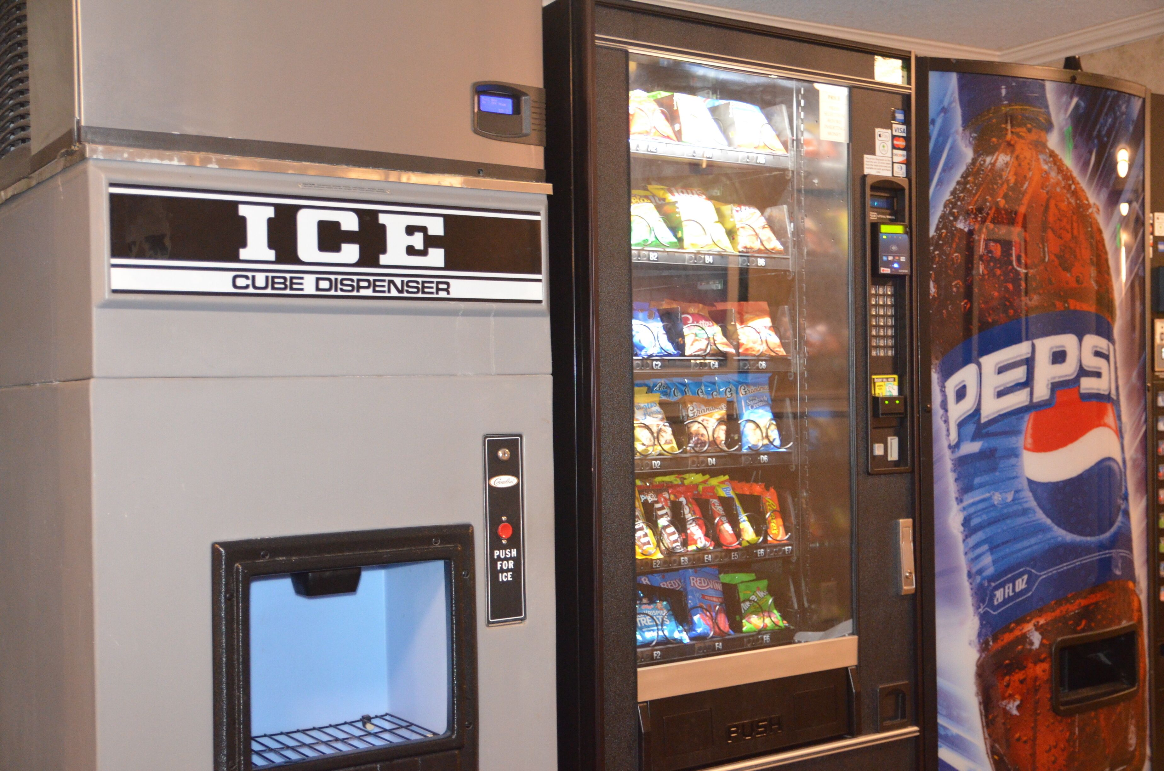 Un distributeur automatique orné d’une publicité pour Pepsi et muni d’un compartiment à glaçons étiqueté « GLACE ».
