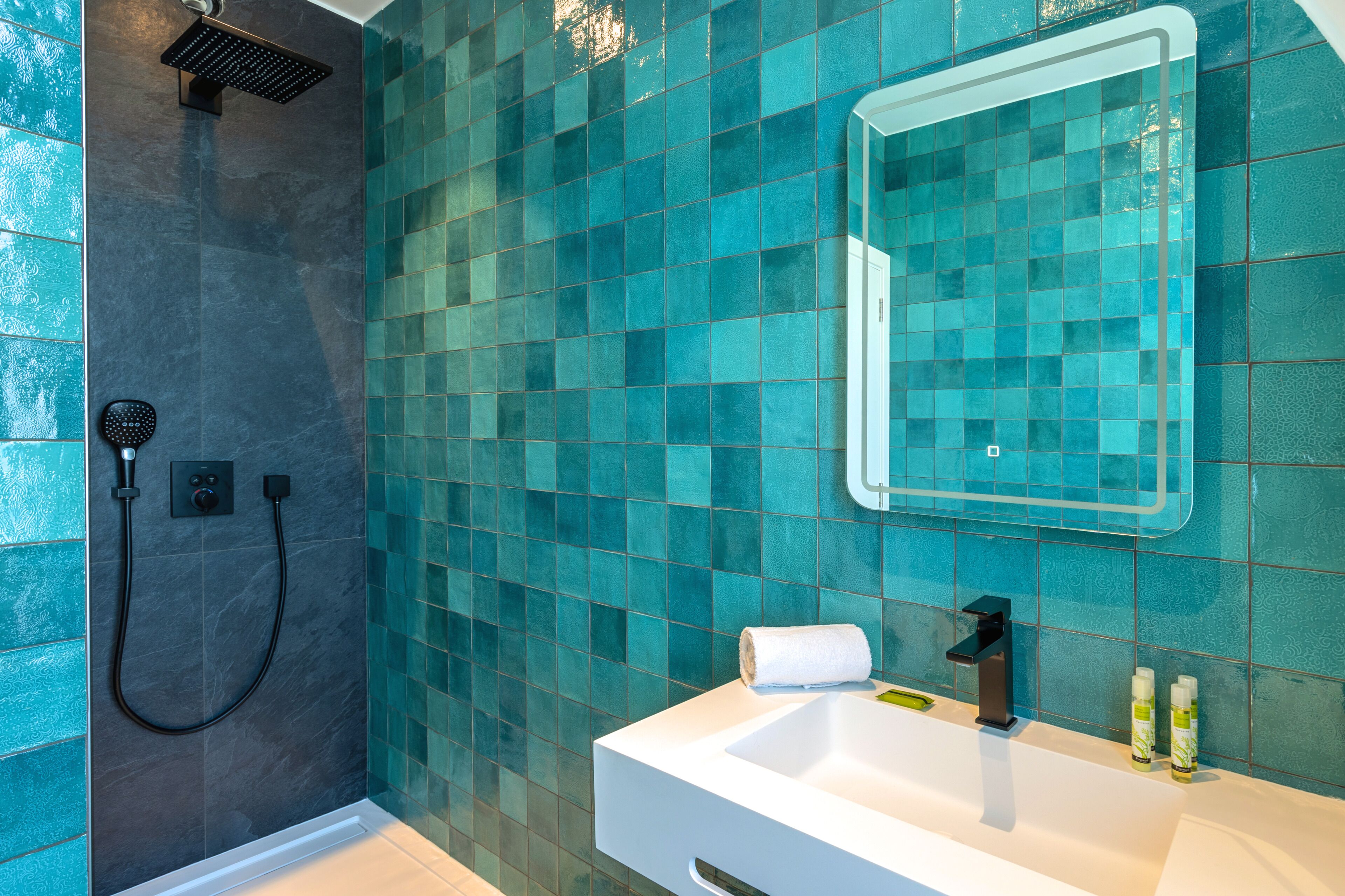 A bathroom with a shower, a sink, and a mirror.