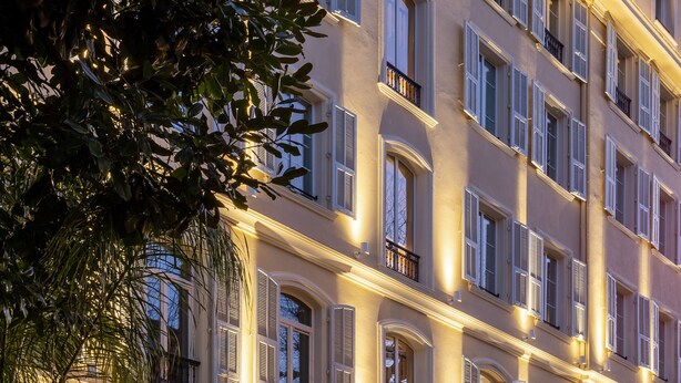 Un hotel de varios pisos con un estilo arquitectónico clásico, que cuenta con ventanas arqueadas y balcones.
