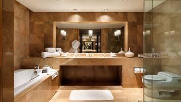 A modern bathroom with a large mirror, a bathtub, a shower, and a toilet.