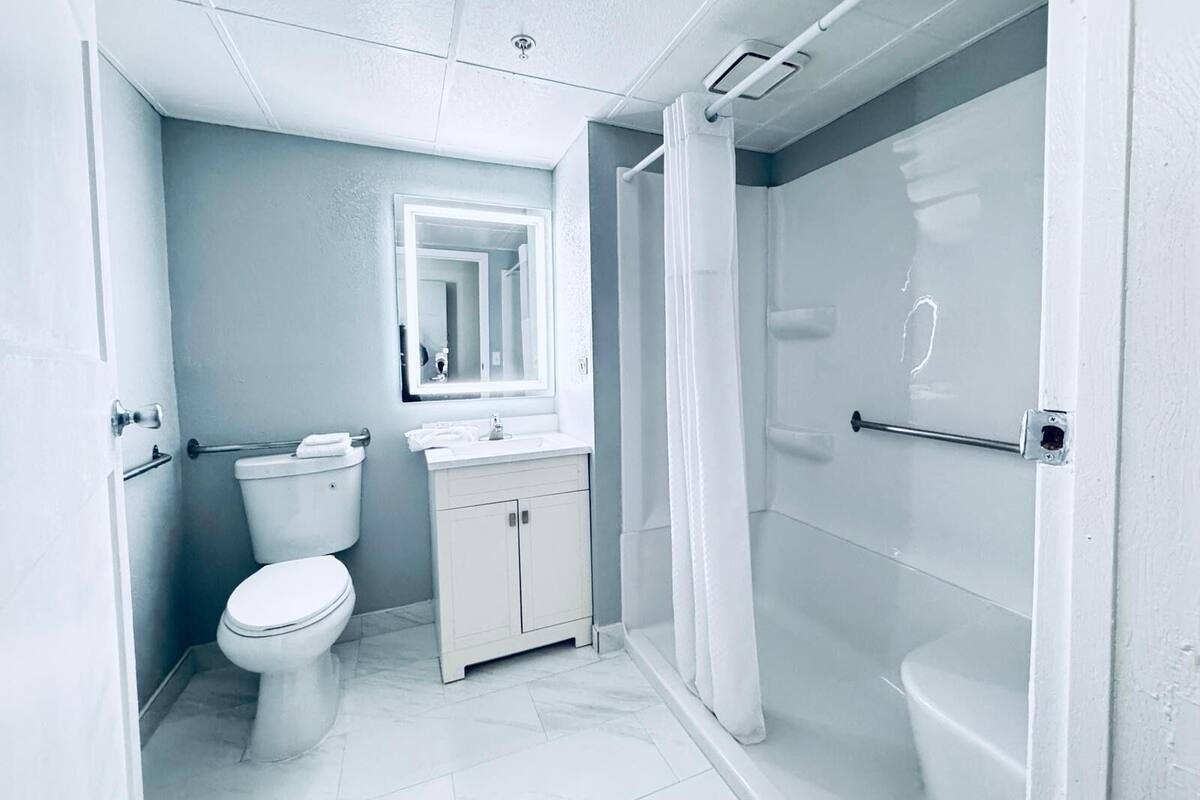 A modern bathroom with a toilet, sink, and shower.
