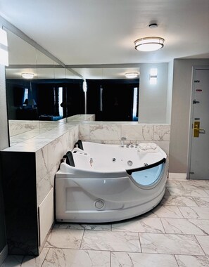 Une salle de bain moderne avec une baignoire sur pieds, un revêtement de sol en marbre et un grand miroir.