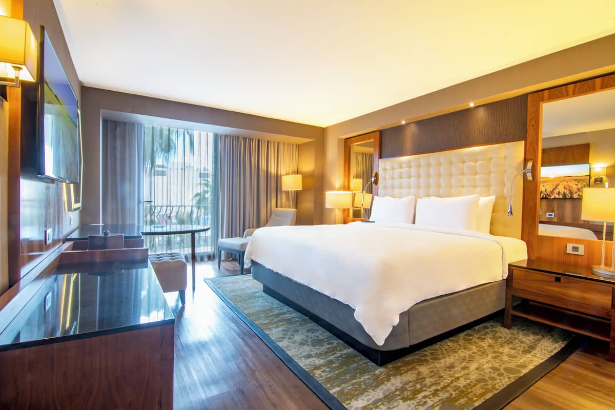 Ein modernes Hotelzimmer mit einem großen Bett, einem Schreibtisch und einer Sitzecke.
