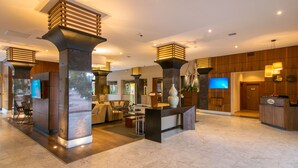 A modern lobby with a reception desk, seating area, and a TV screen. - Hotel Lucerna Tijuana (Tijuana)