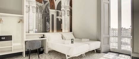Una habitación de hotel con cama, escritorio y ventana grande.
