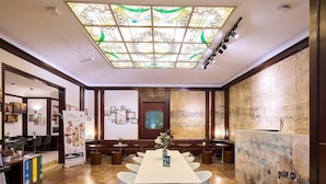 A spacious dining area with a high ceiling and a stained glass window. There are multiple seating options including a long table and several booths. The walls feature artwork and a large mural. - B&B Hotel Napoli (Naples)