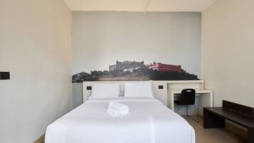 Ein Hotelzimmer mit Bett, Schreibtisch und Stuhl.