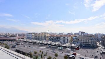 A cityscape with a large open plaza, buildings, and a distant mountain.