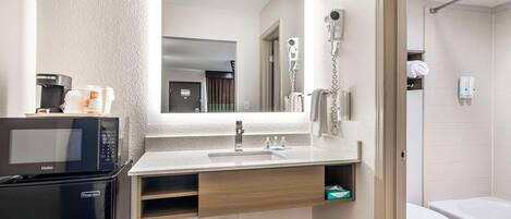 Un baño moderno con horno microondas integrado, secador de pelo y retrete.