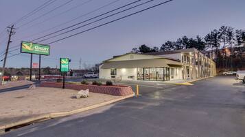 A motel with a sign advertising "Quality Inn & Suites" and a new opening.