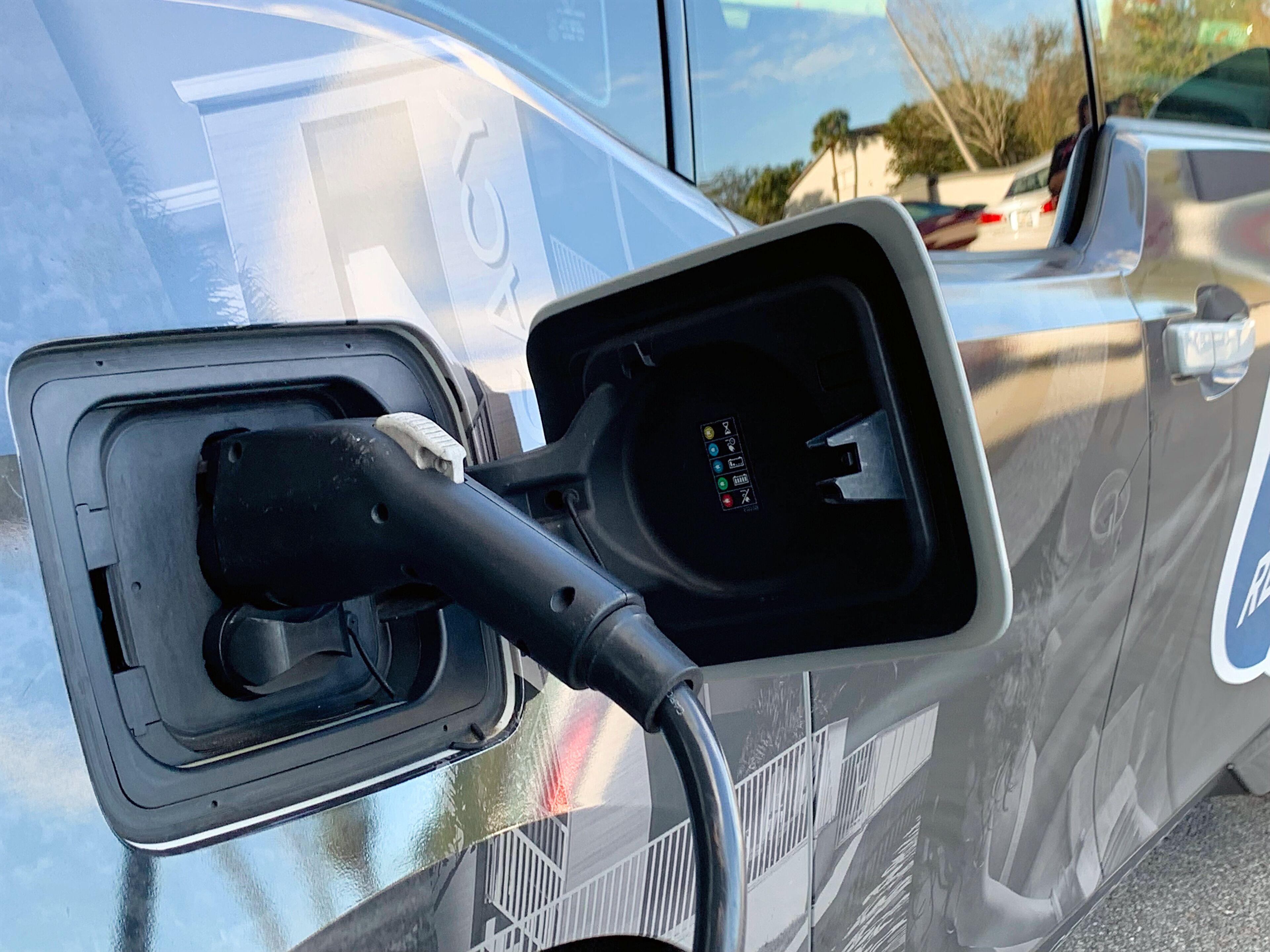 A close-up of a vehicle's side mirror with a charging port.