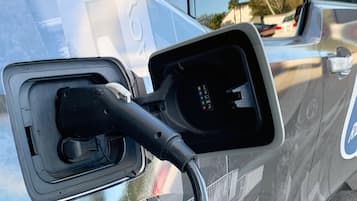 A close-up of a vehicle's side mirror with a charging port.