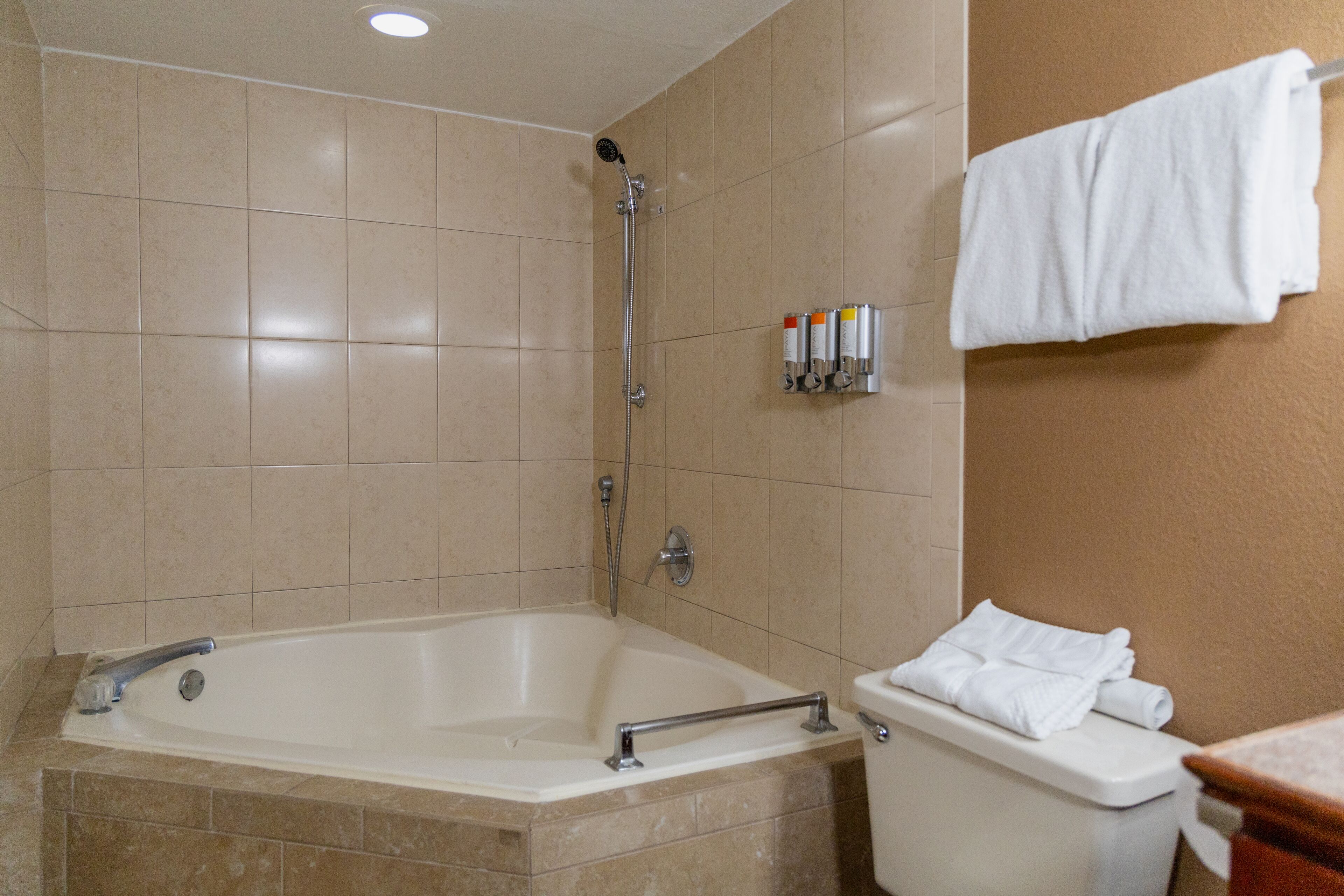 A bathroom with a bathtub, a toilet, and a towel rack.