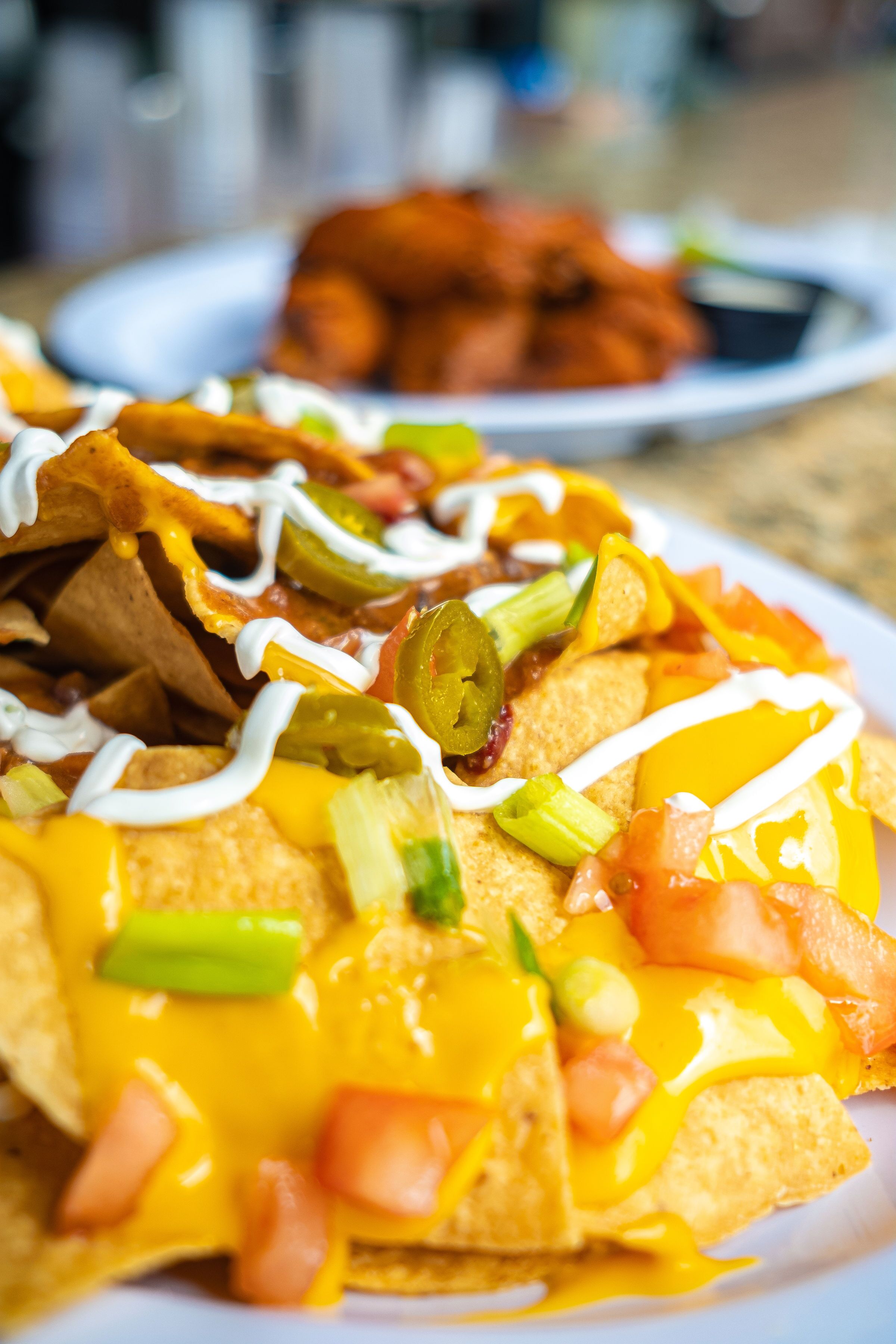 Nachos topped with cheese, jalapeños, and sour cream.