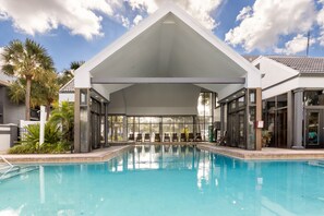 A swimming pool with a covered seating area and palm trees in the background. - Legacy Vacation Resorts - Kissimmee/Orlando (Kissimmee)