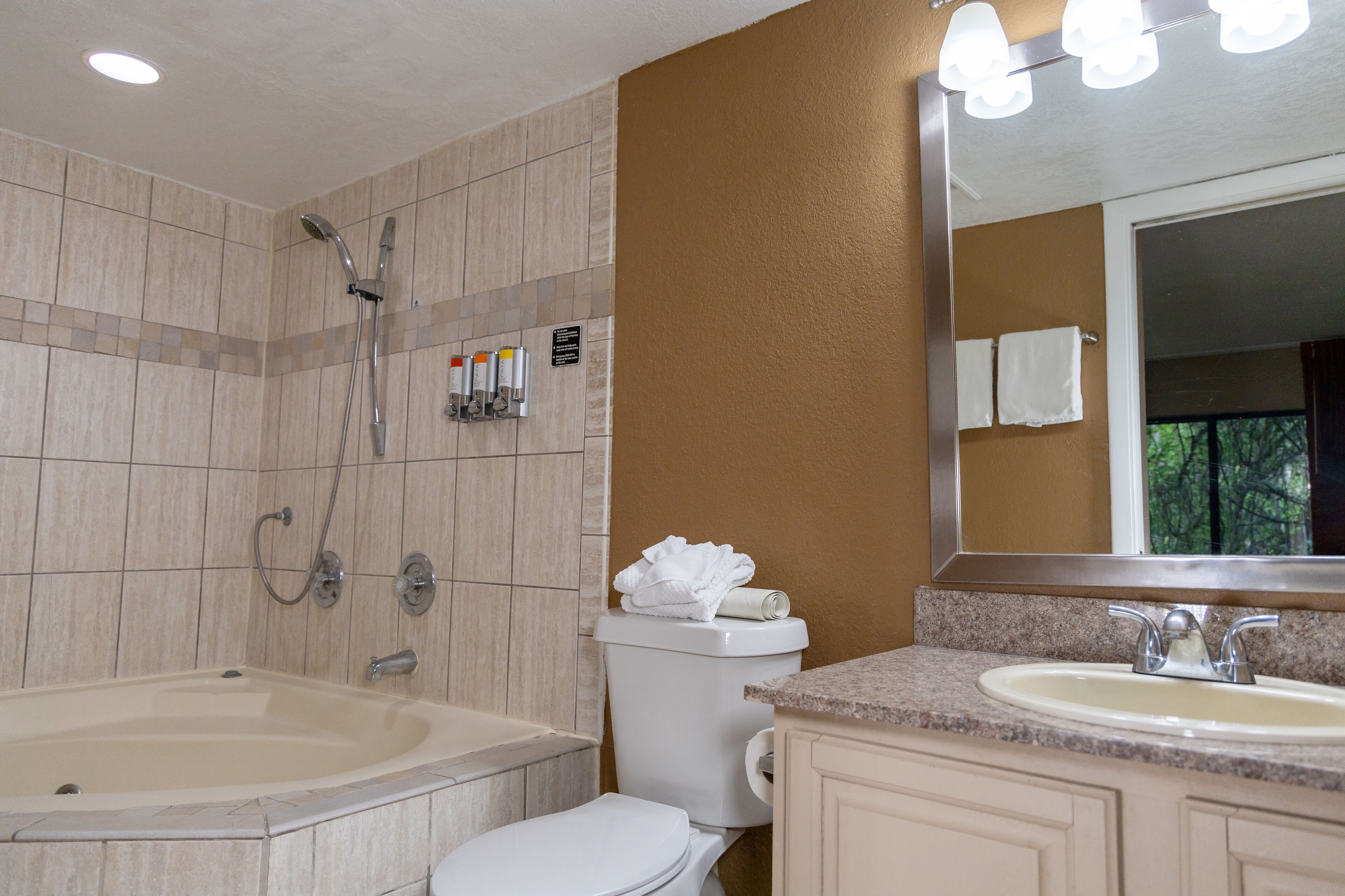 Une salle de bain équipée d’une baignoire, de toilettes, d’un lavabo et d’un miroir.