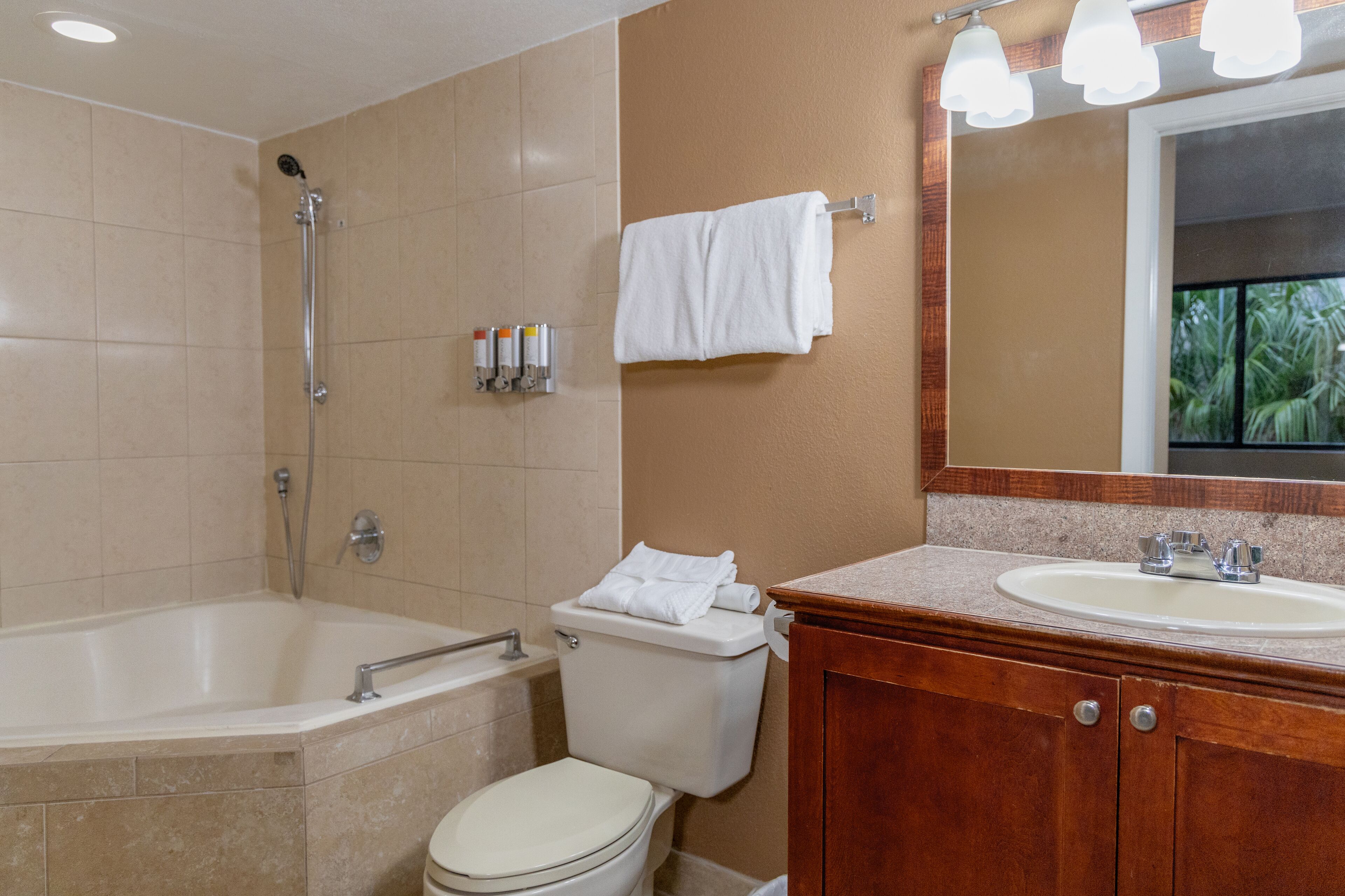 A bathroom with a bathtub, toilet, sink, and mirror.