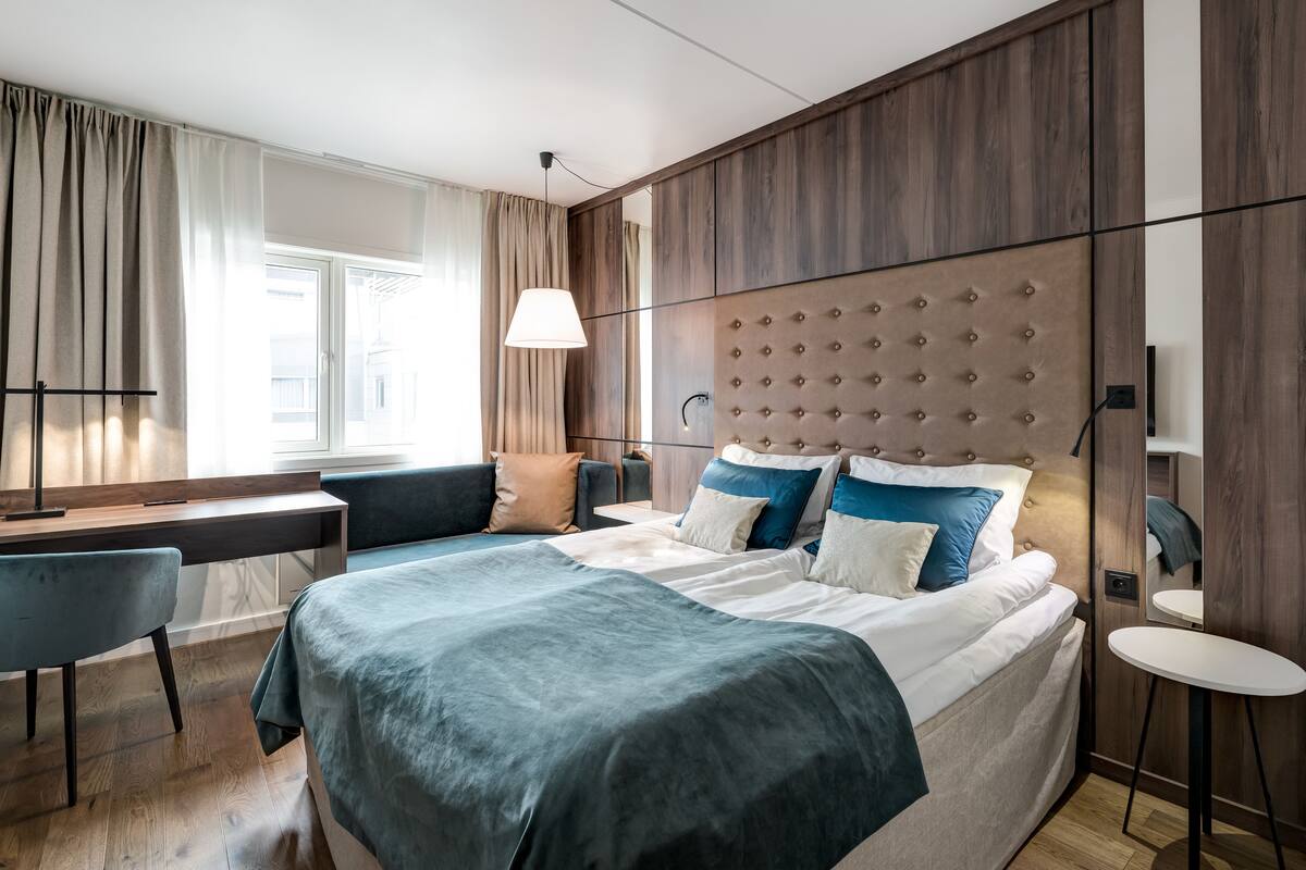Een moderne slaapkamer met een groot bed, een bureau en een stoel.