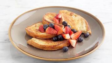 A plate of French toast with strawberries and blueberries.