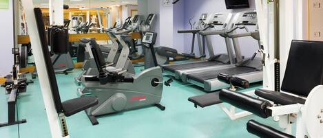 A gym with various exercise machines, including treadmills and weight stations.