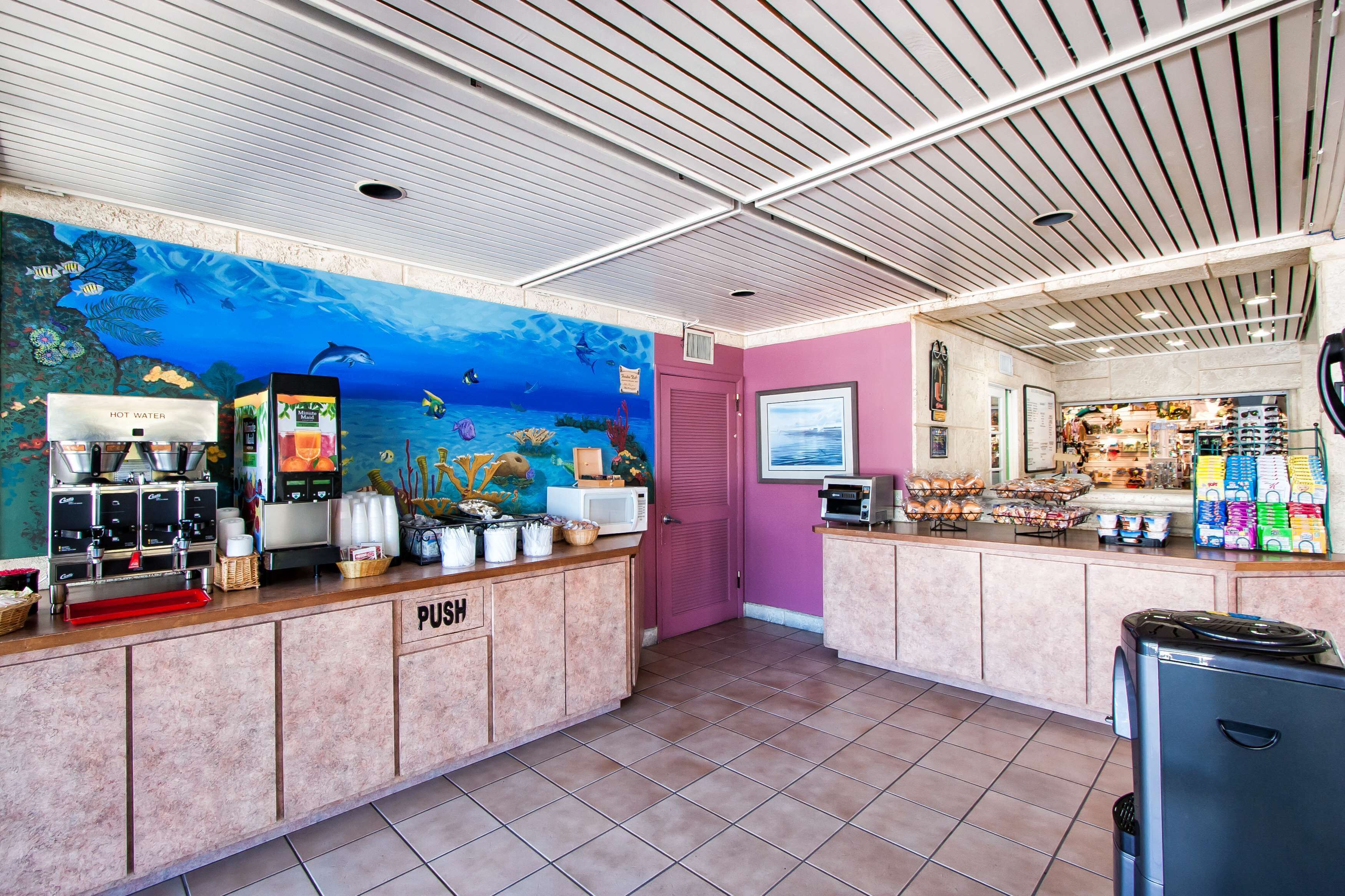 A restaurant with a marine-themed mural, a push button for service, and a variety of food items on display.