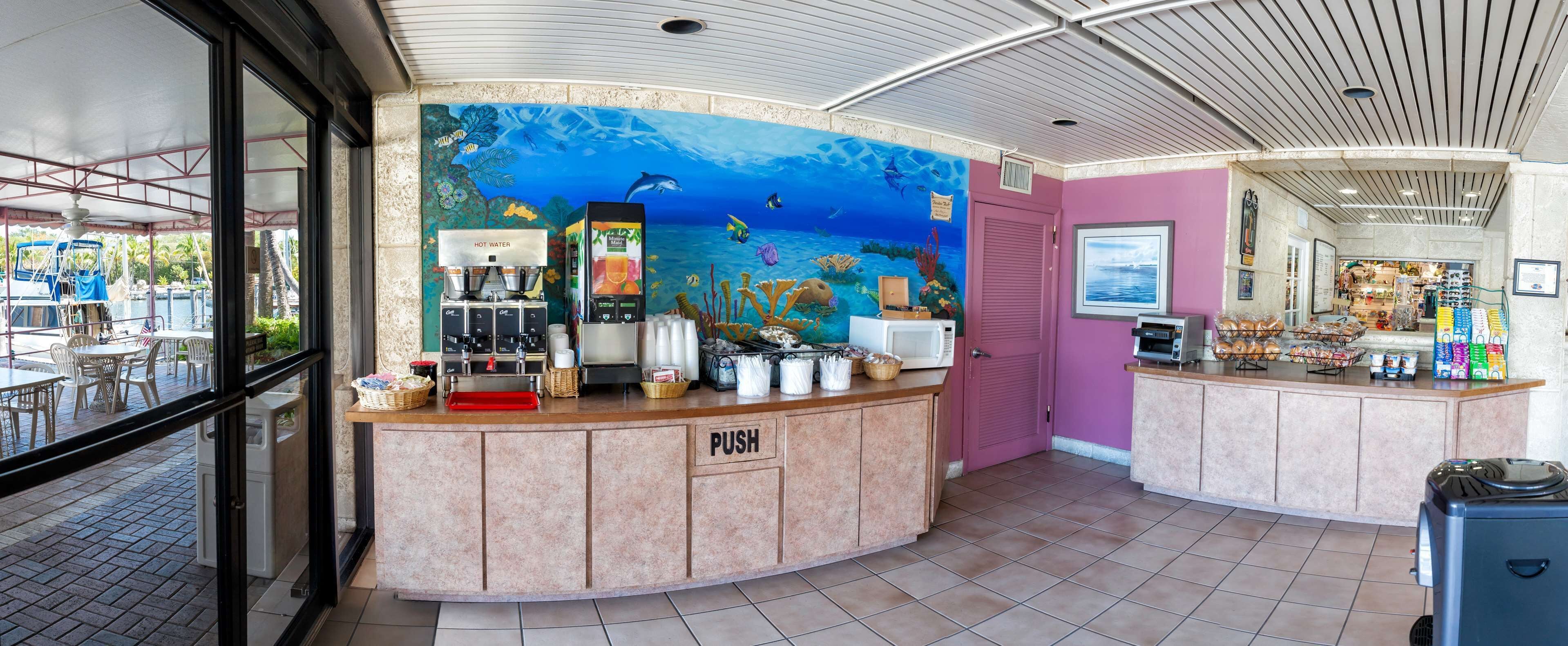 Un mostrador con un cartel que dice 'PUSH', una estación de agua caliente y un dispensador de bebidas.