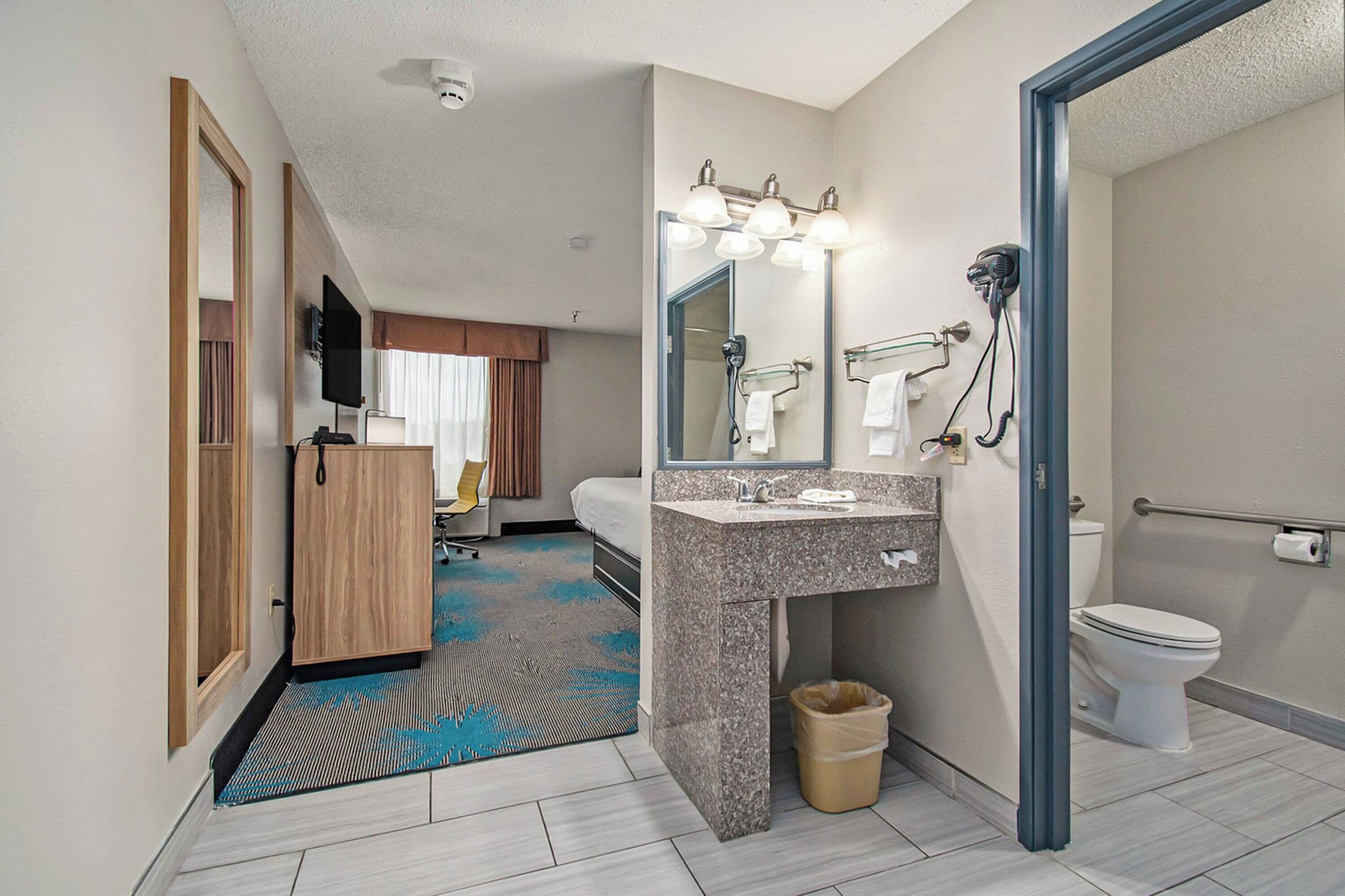Un baño de hotel con ducha, lavamanos e inodoro.