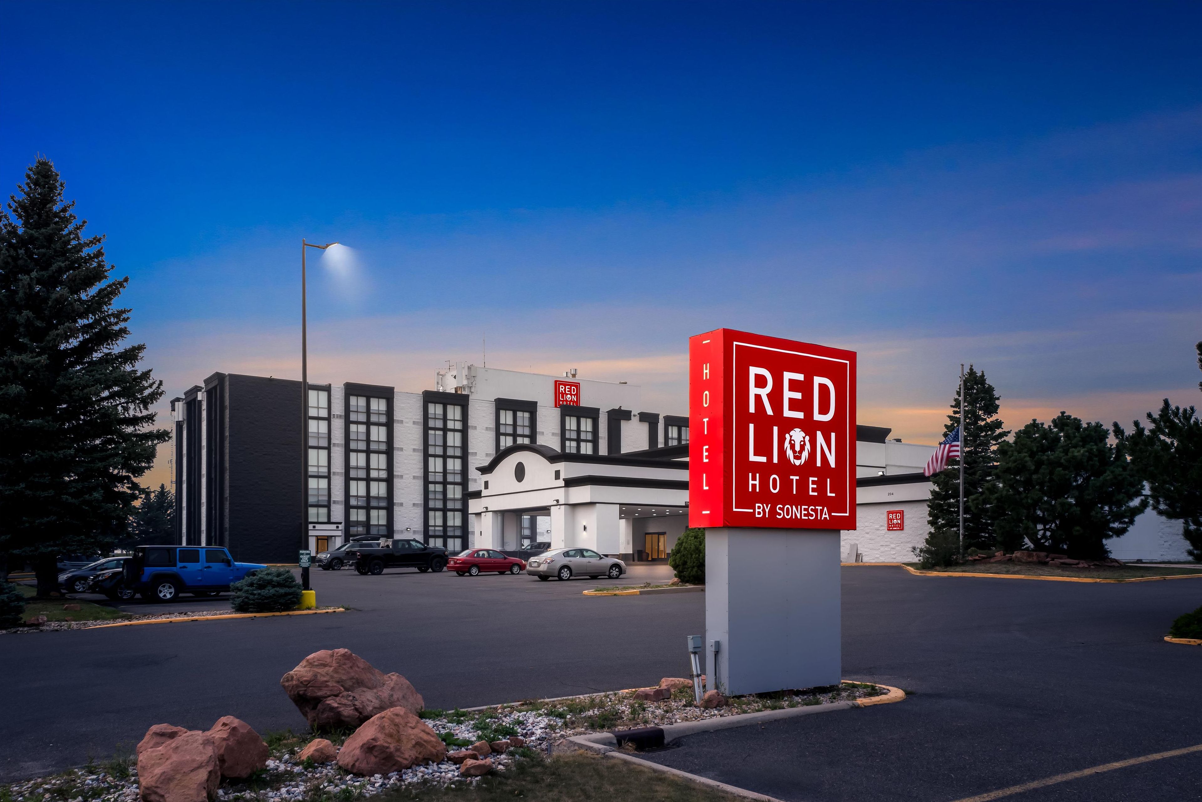 A Red Lion Hotel sign with a modern building in the background.