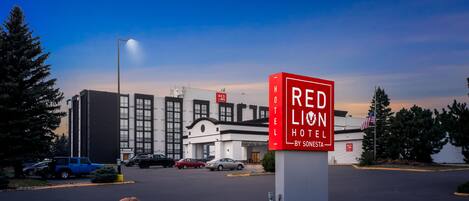 A Red Lion Hotel sign with a modern building in the background.