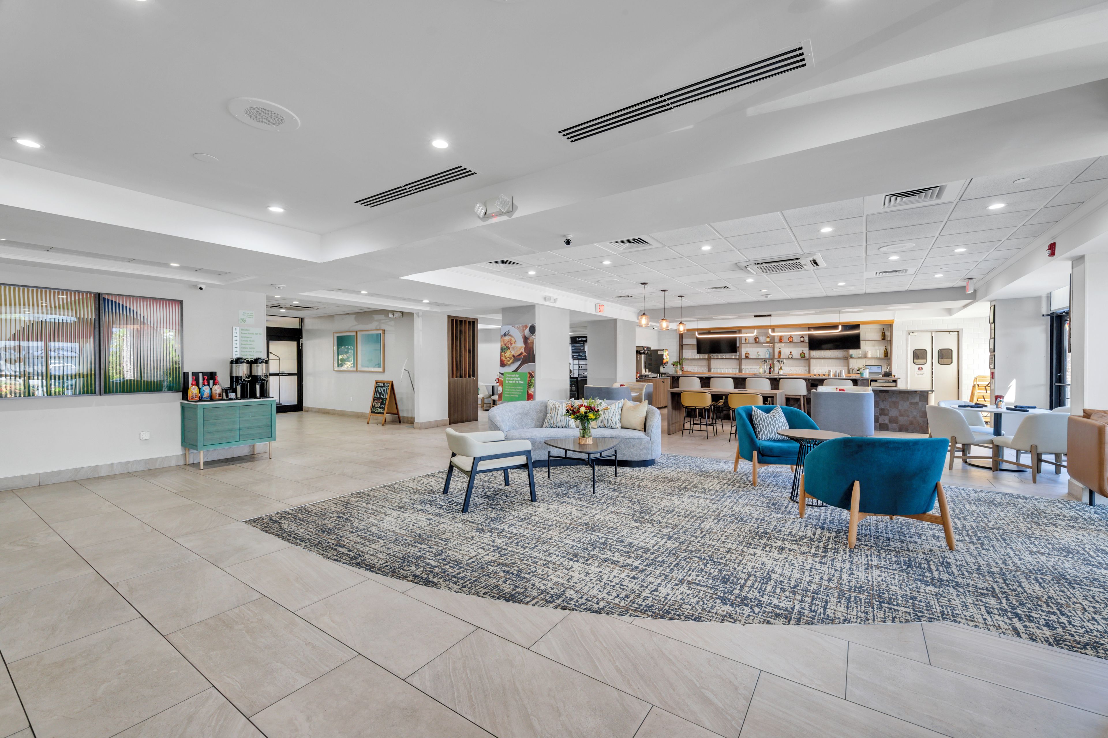 A spacious lobby with a seating area, a kitchenette, and a bakery.