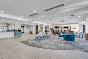 A spacious lobby with a seating area, a kitchenette, and a bakery. - Holiday Inn Atlanta-Northlake by IHG (Atlanta)